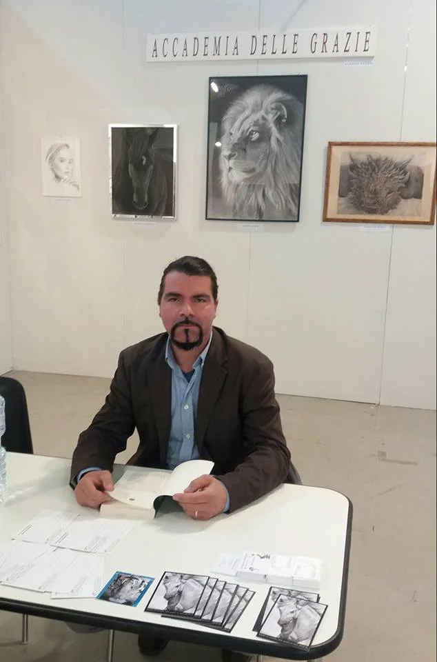 Alessio Atzeni davanti a una parete di disegni dell’Accademia delle Grazie